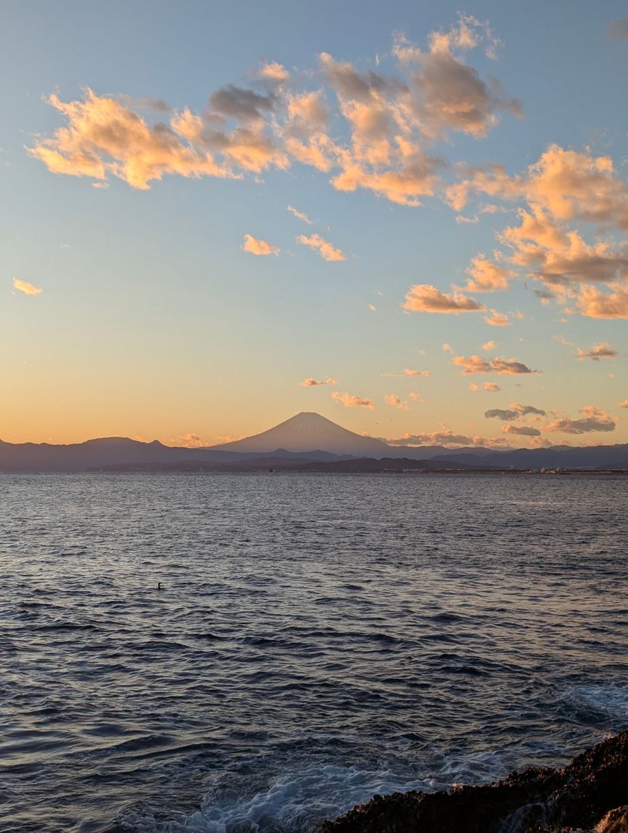 海に沈む夕日と富士山（イメージ写真）